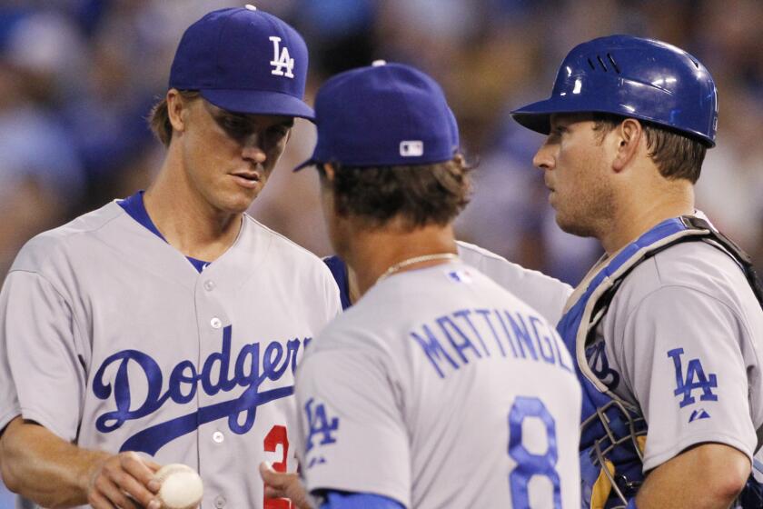 Dodgers pitcher Zack Greinke, left, hands off the ball to Manager Don Mattingly, center, as he leaves the game, as catcher A.J. Ellis looks on in the sixth inning of the Dodgers' 5-3 loss to the Kansas City Royals on Monday.