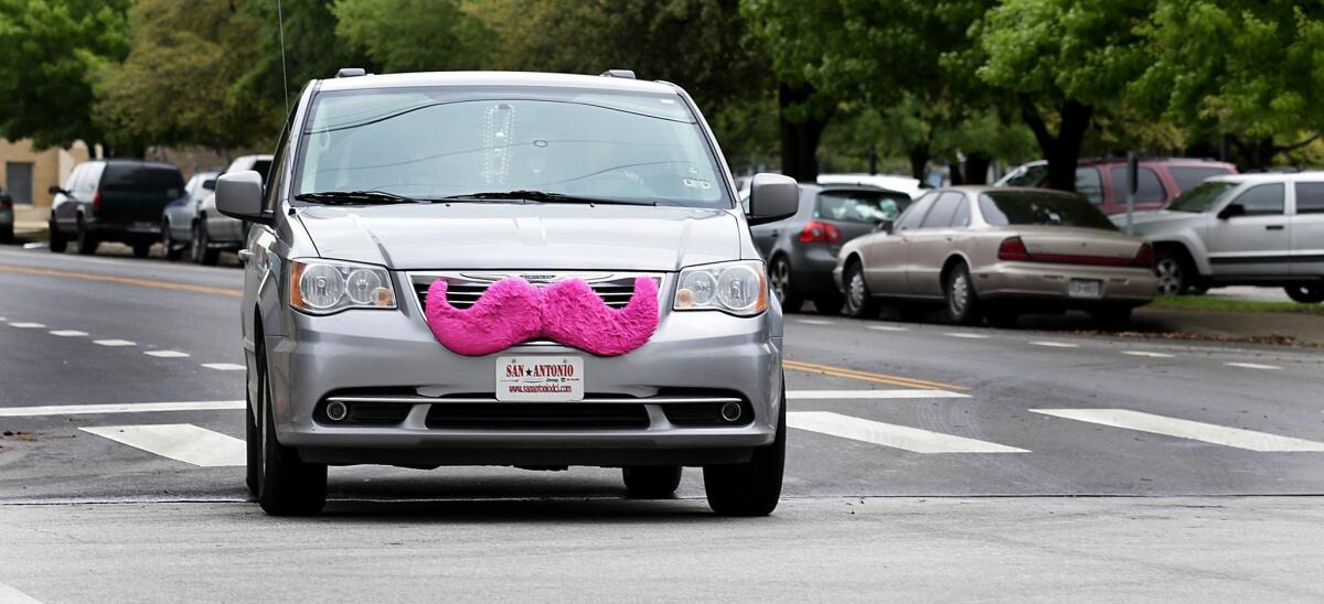 A Lyft car with a signature pink mustache makes its way along a San Antonio street. The ride-hailing company is among many businesses in the sharing economy that are reducing the amount millennials spend on summer vacation, according to a new survey.