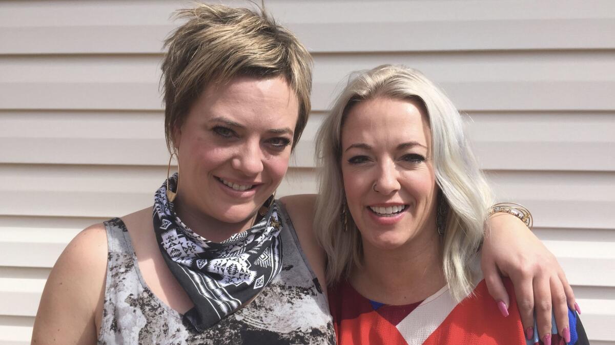 Robin McIntyre, left, with her sister Jessica in the backyard of Jessica's Denver home. Robin carries the gene mutation for early onset Alzheimer's disease.