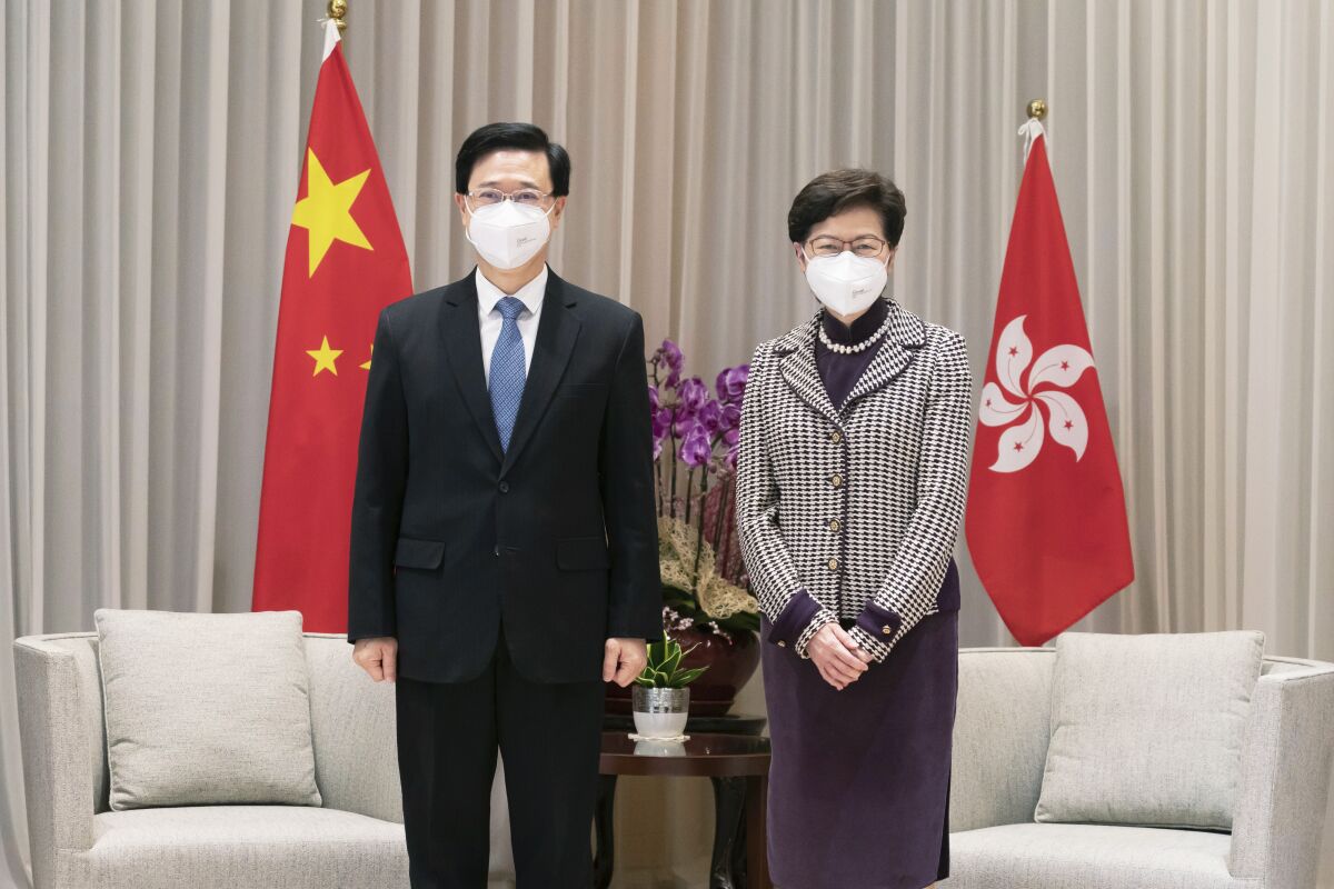 Hong Kong Chief Executive-elect John Lee, left, and Chief Executive Carrie Lam pose for a photo during a meeting at the Central Government Complex ahead of a news conference in Hong Kong, Monday, May 9, 2022. (Anthony Kwan/Pool Photo via AP)