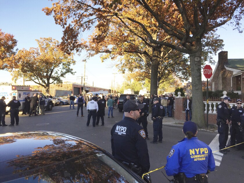 New York City Police officers gather at a shooting scene in the Bronx.