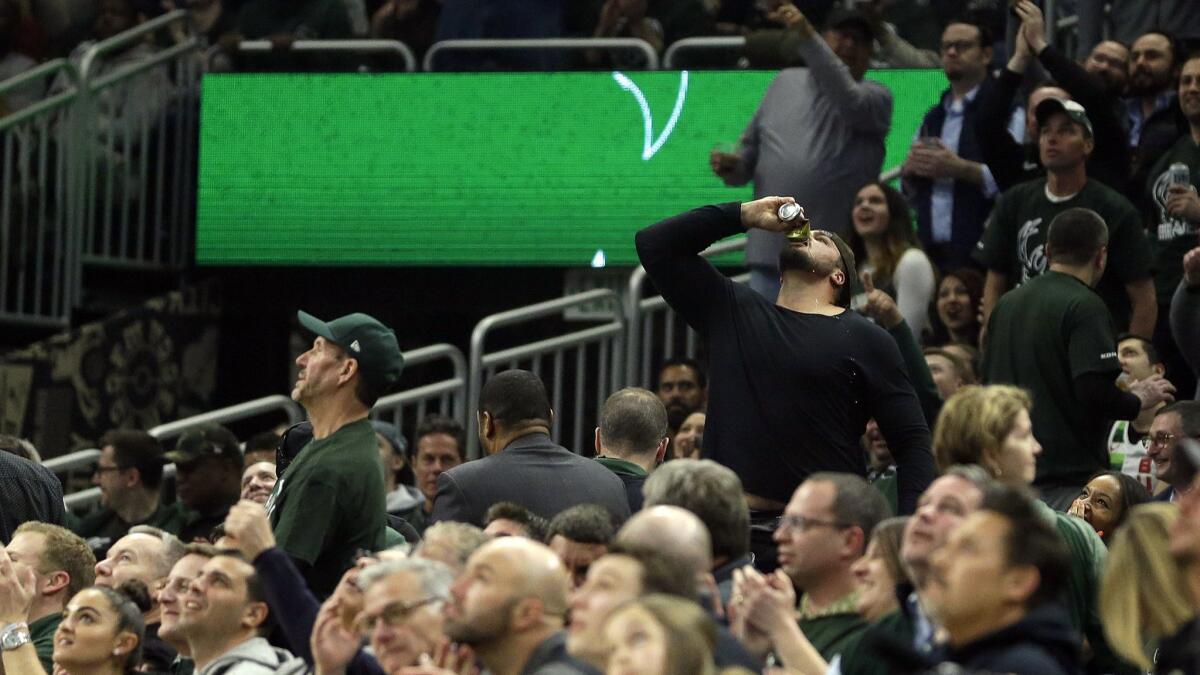 Green Bay Packers' offensive lineman David Bakhtiari chugs a beer during a April 17 playoff game between the Milwaukee Bucks and the Detroit Pistons in Milwaukee.