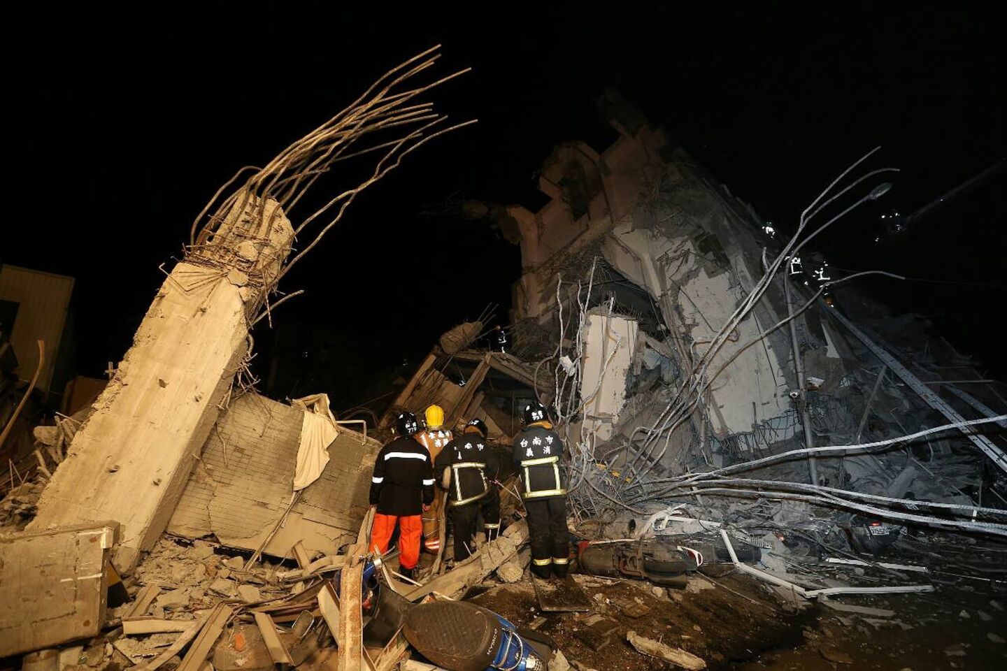 Rescue personnel search through debris at the site of a collapsed building in the southern Taiwanese city of Tainan following a 6.4 magnitude earthquake that struck the island early Feb. 6.