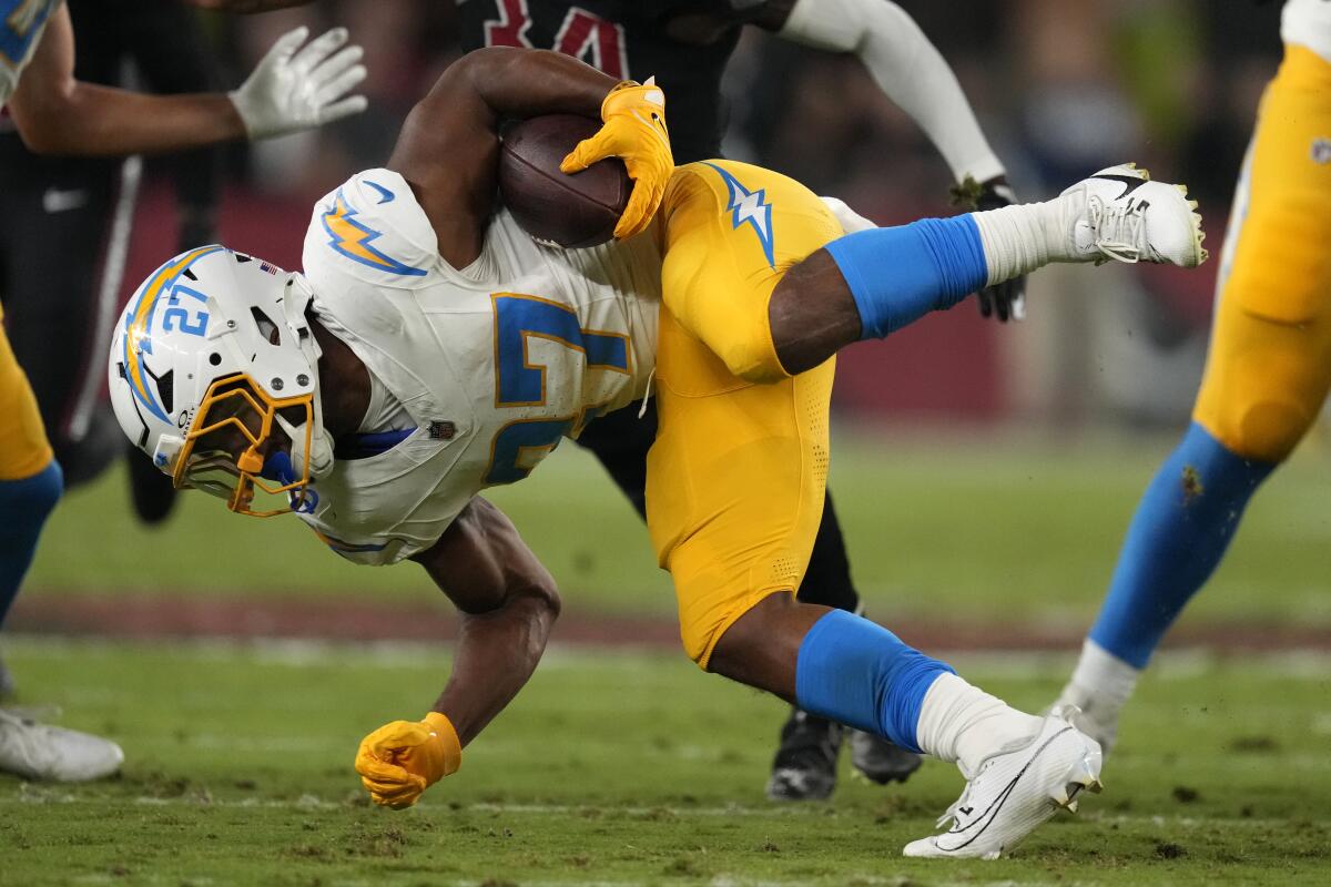 Chargers running back J.K. Dobbins is brought down during the first half against the Cardinals on Monday.