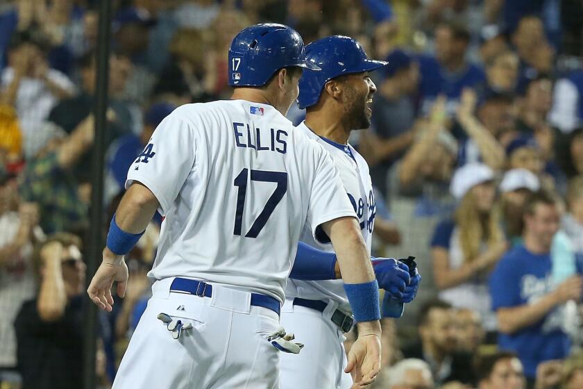 A.J. Ellis and Matt Kemp celebrate after scoring on a three-run double from pitcher Dan Haren in the fourth inning of the Dodgers' 6-4 win over the Arizona Diamondbacks.