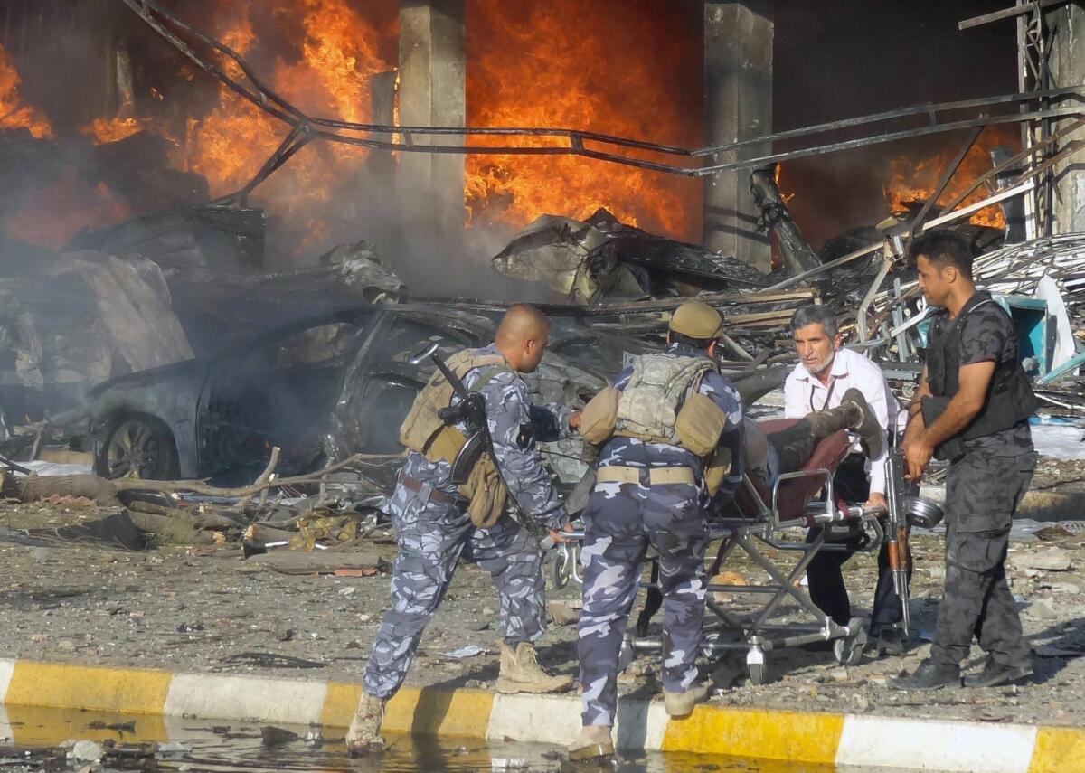 Iraqi emergency personnel remove a body from the site of a bomb attack on Aug. 23, 2014, the northern city of Kirkuk.