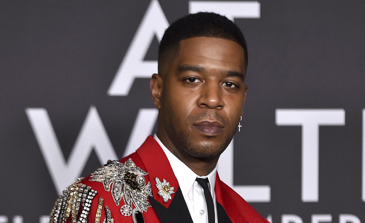 Kid Cudi in a red and black jacket with sparkly appliques.