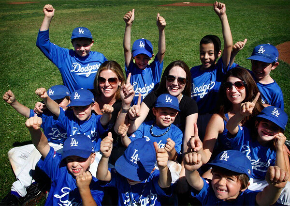 Mom coaches Tracy Chiovare, left, Jen Maljian and Claudia Chiovare pose with their Dodgers little league team following Saturday's game in Arcadia.