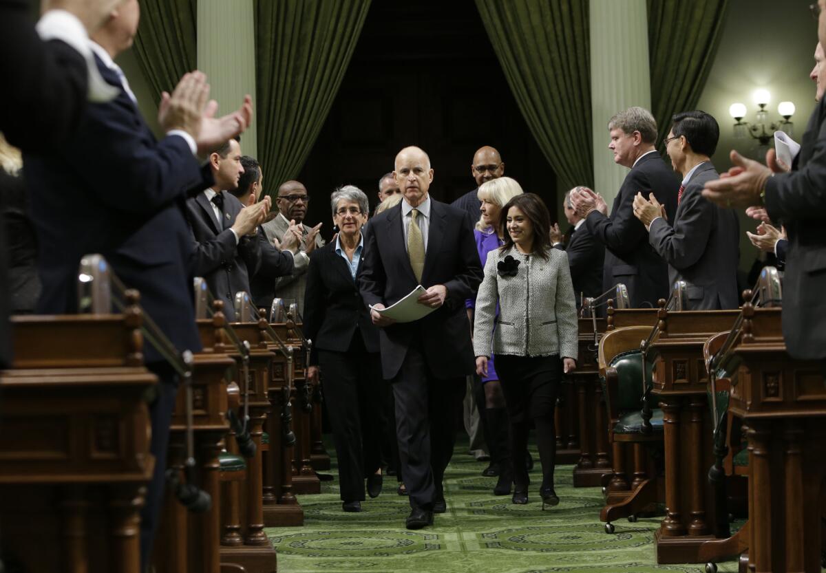 Lawmakers applaud Gov. Jerry Brown as he enters the Assembly chamber to give his State of the State address.