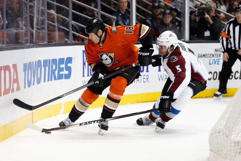 Ducks forward Tim Jackman battles for the puck with Nate Guenin of the Avalanche during a game on Oct. 16.