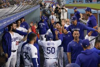 Dodgers' Mookie Betts (50) celebrates with teammates in the dugout after scoring off of a single hit by Freddie Freeman