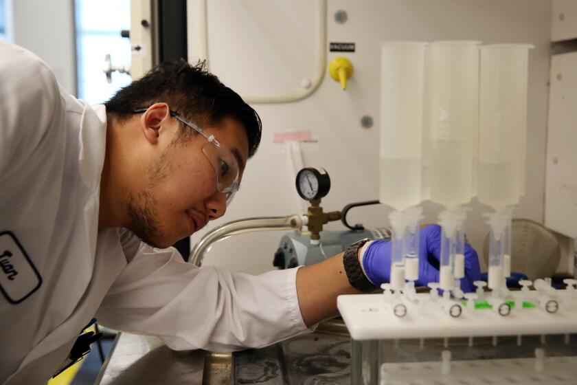 ORANGE COUNTY, CA-OCTOBER 9, 2019: Twan Nguyen checks a manual machine that is testing surface water for PFAS compounds at the Orange County Water District on October 9, 2019 in Orange County, California. Officials will release new water quality results this week that will show widespread contamination of PFAS, a toxic chemical linked to cancer. (Photo By Dania Maxwell / Los Angeles Times)