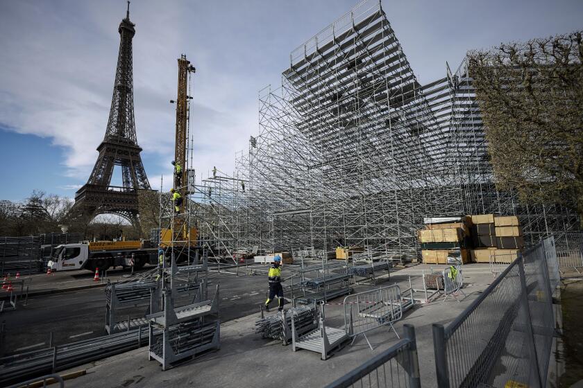 ARCHIVO - Trabajadores construyen gradas para los venideros Juegos Olímpicos en el Campo de Marte, justo al lado de la Torre Eiffel, en París, el 1 de abril de 2024. (AP Foto/Thomas Padilla)