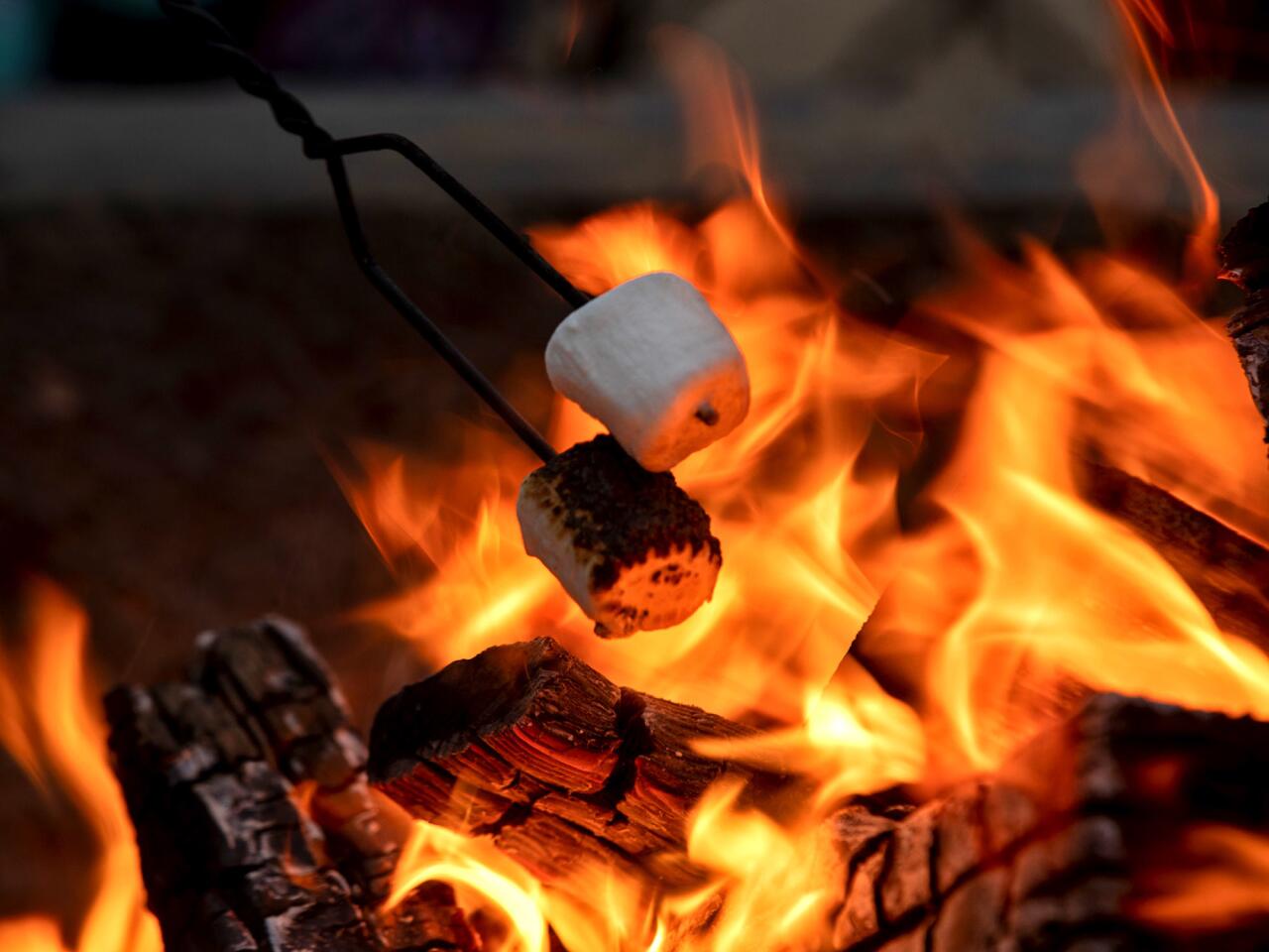 Campers roast marshmallows over a fire at dusk at Bolsa Chica State Beach.