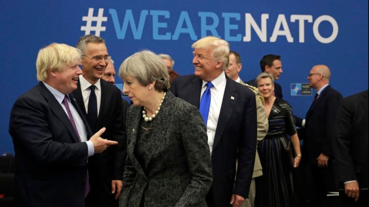 At the 2017 NATO summit in Brussels, President Trump jokes with British Foreign Minister Boris Johnson as British Prime Minister Theresa May walks past. Johnson resigned on Monday to protest May's Brexit policy.