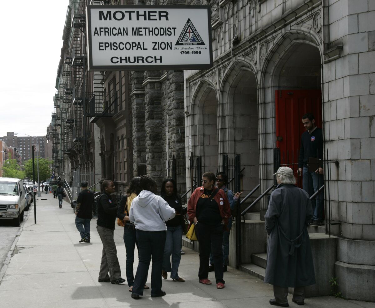 A group of people on the sidewalk outside a church in Harlem
