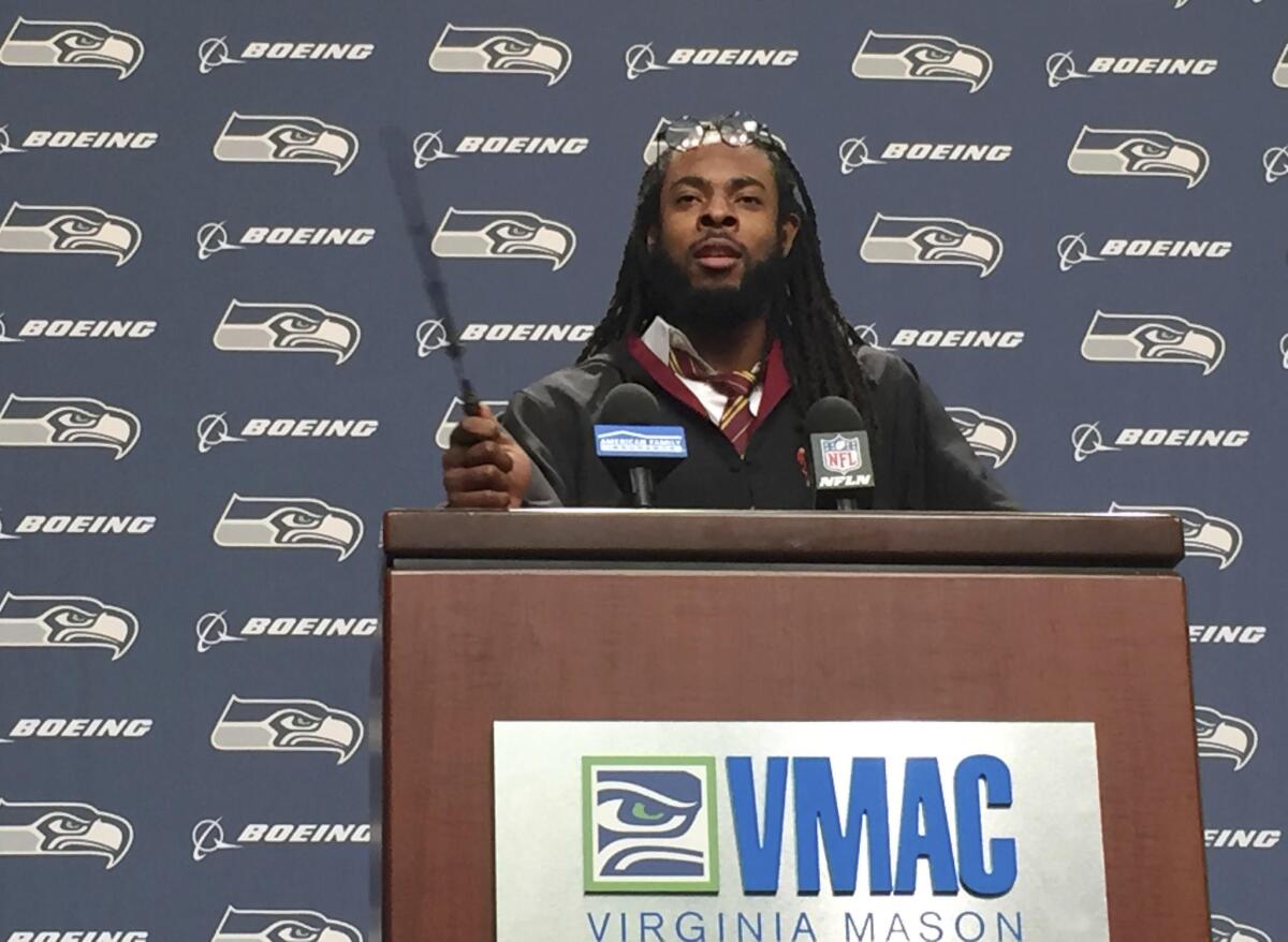Seattle Seahawks cornerback Richard Sherman talks to reporters while dressed as Harry Potter on Wednesday. Why? Because his son asked him to.