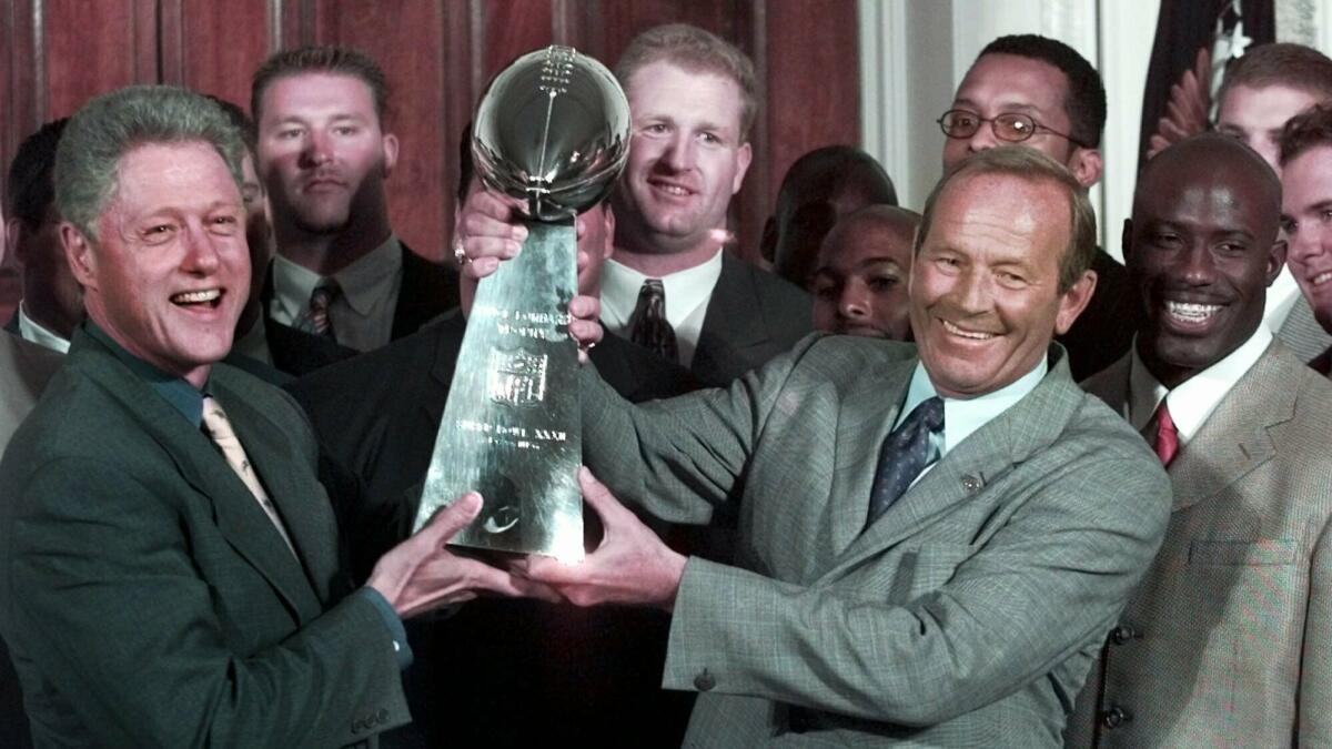 President Clinton, left, and Denver Broncos owner Pat Bowlen hold the Vince Lombardi Trophy during a Super Bowl victory celebration at the White House in June 1998.