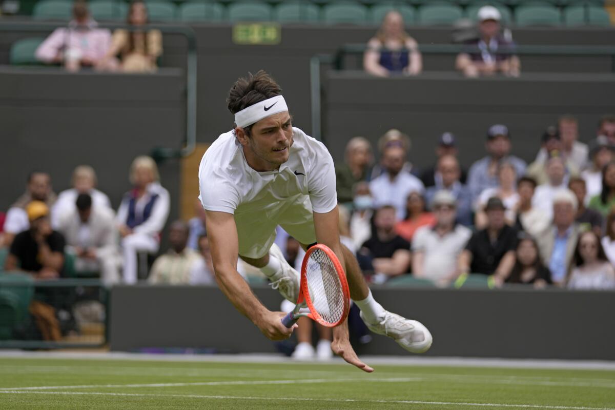 Taylor Fritz dives to return a shot at Wimbledon.