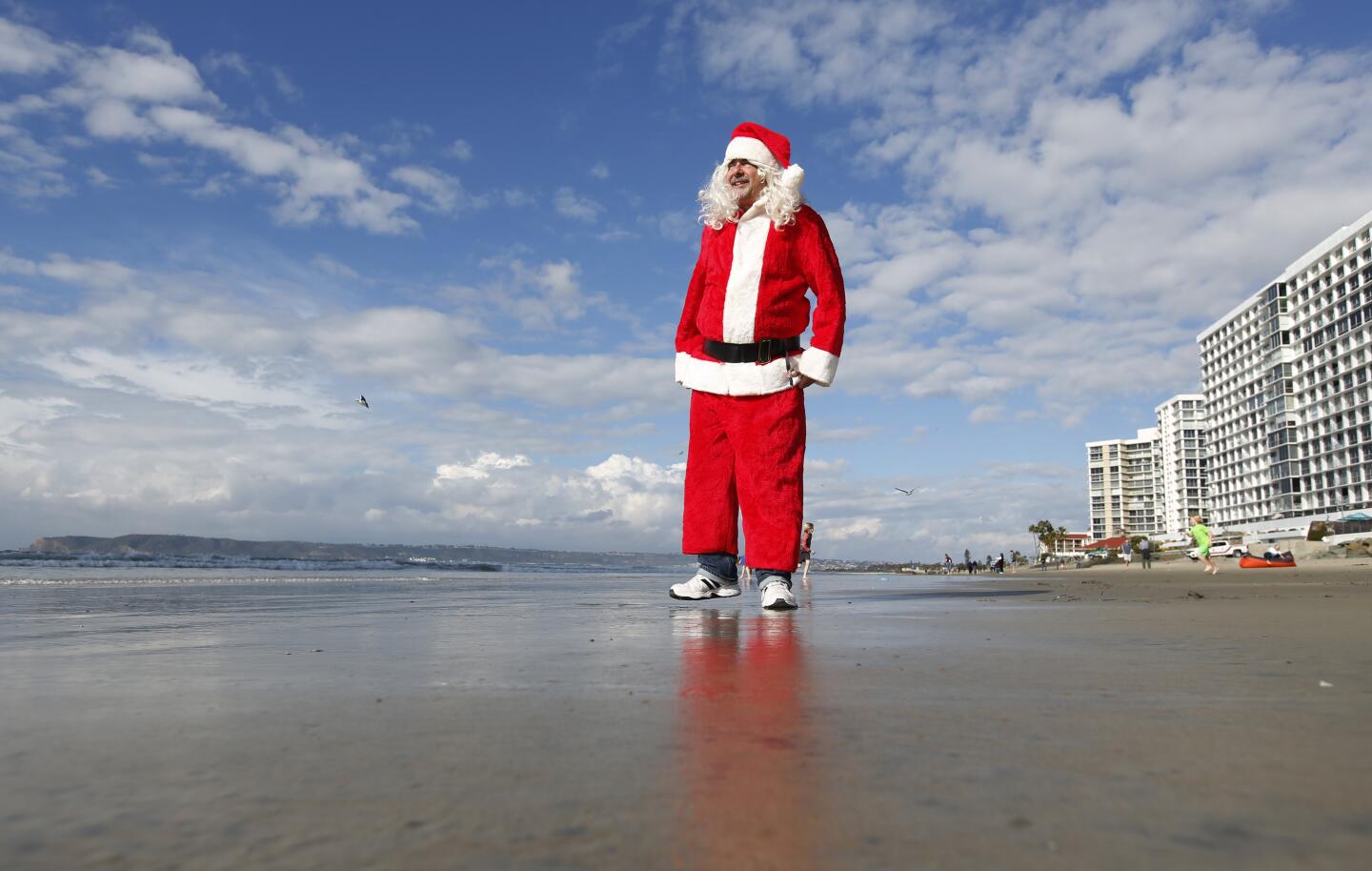 Alan Zada, dressed as Santa Claus, came down to greet surfers during the 9th Annual URT Santa Surf Off and Toy Drive in Coronado on Dec. 24, 2019.