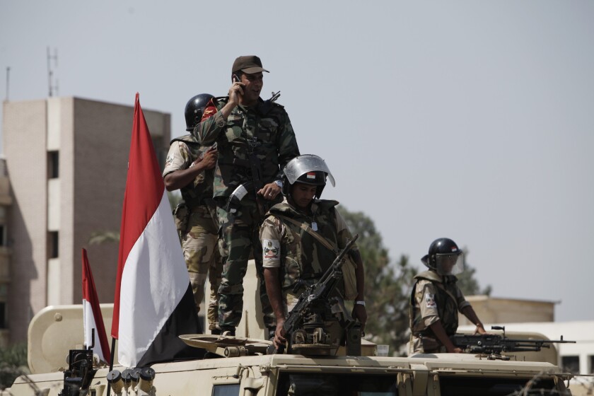 Egyptian soldiers stand guard in front of the headquarters of the Republican Guard in Nasr City.