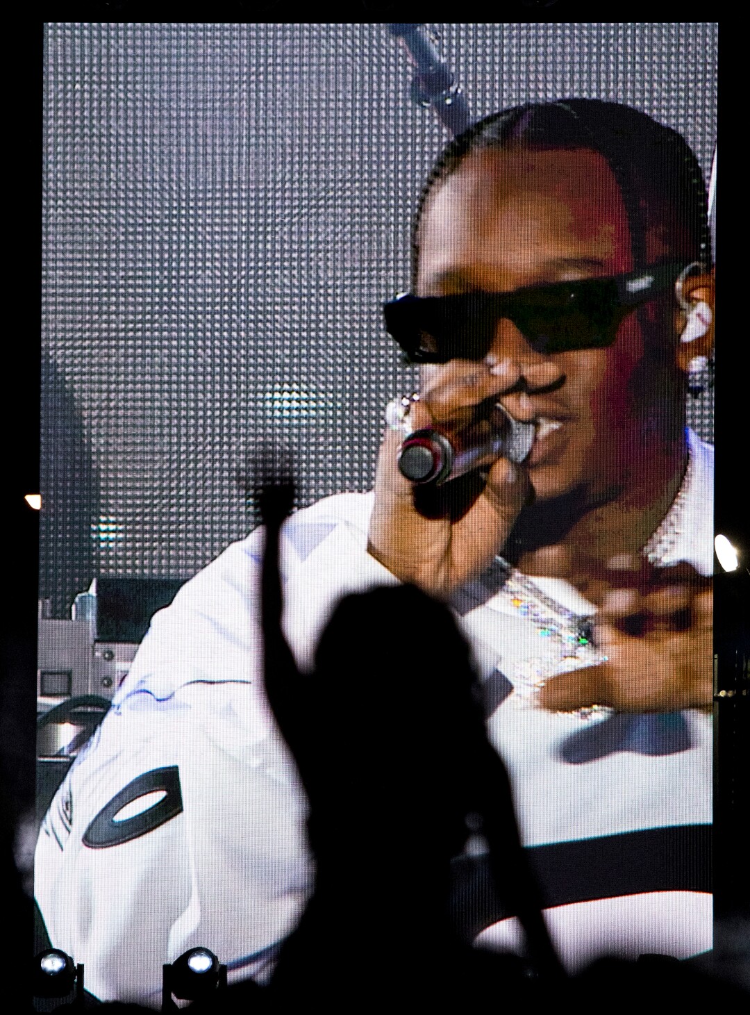 A fan is silhouetted against the screen Blxst performs