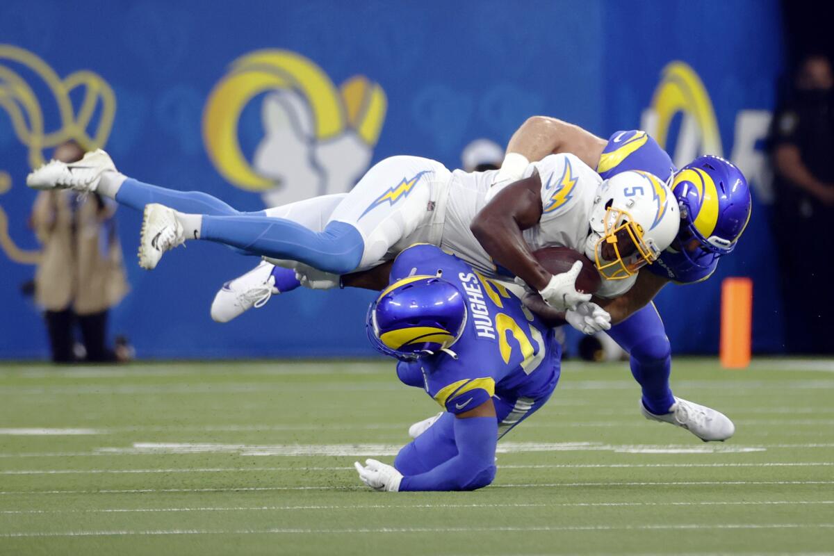 Chargers wide receiver Josh Palmer (5) is tackled by  Rams defensive back JuJu Hughes (23) in preseason opener.