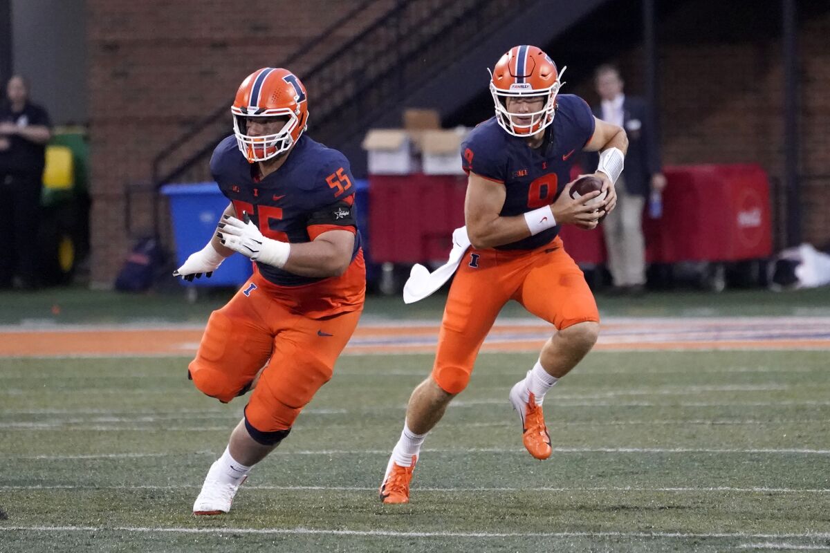 Illinois quarterback Artur Sitkowski (9) scrambles behind the blocking of Blake Jeresaty during the first half of an NCAA college football game against UTSA, Saturday, Sept. 4, 2021, in Champaign, Ill. (AP Photo/Charles Rex Arbogast)