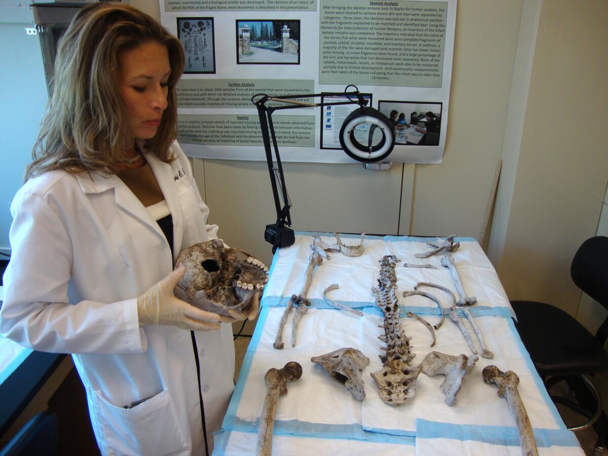 Lori Baker, an associate professor of forensic anthropology at Baylor University, inventories human remains recovered last month on a South Texas ranch. Baker and other researchers recently discovered a series of mass immigrant graves in a Brooks County, Texas, cemetery.