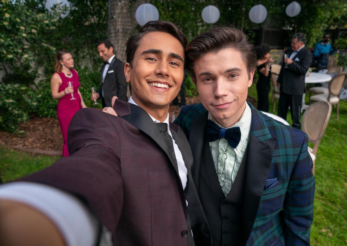 Two men in suits take a selfie.