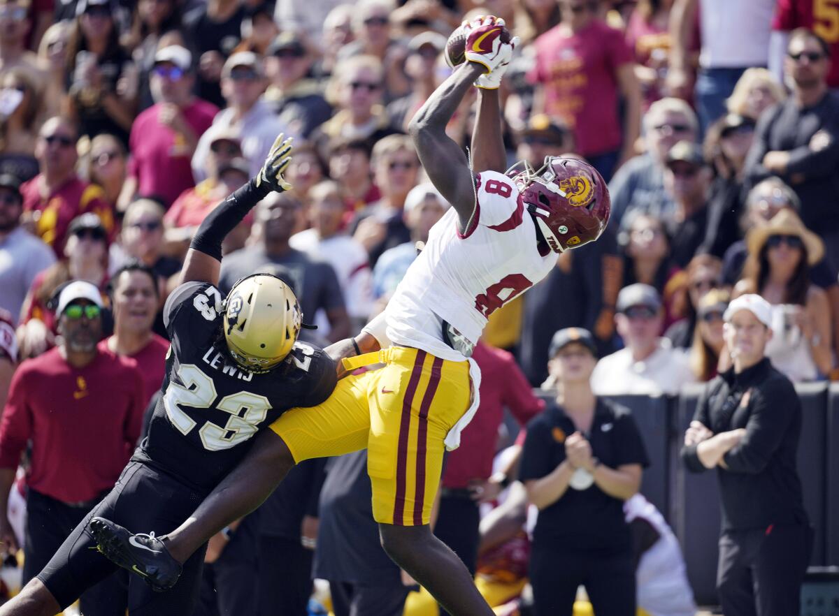 Southern California tight end Michael Trigg, right, pulls in a pass for a touchdown as Colorado safety Isaiah Lewis.