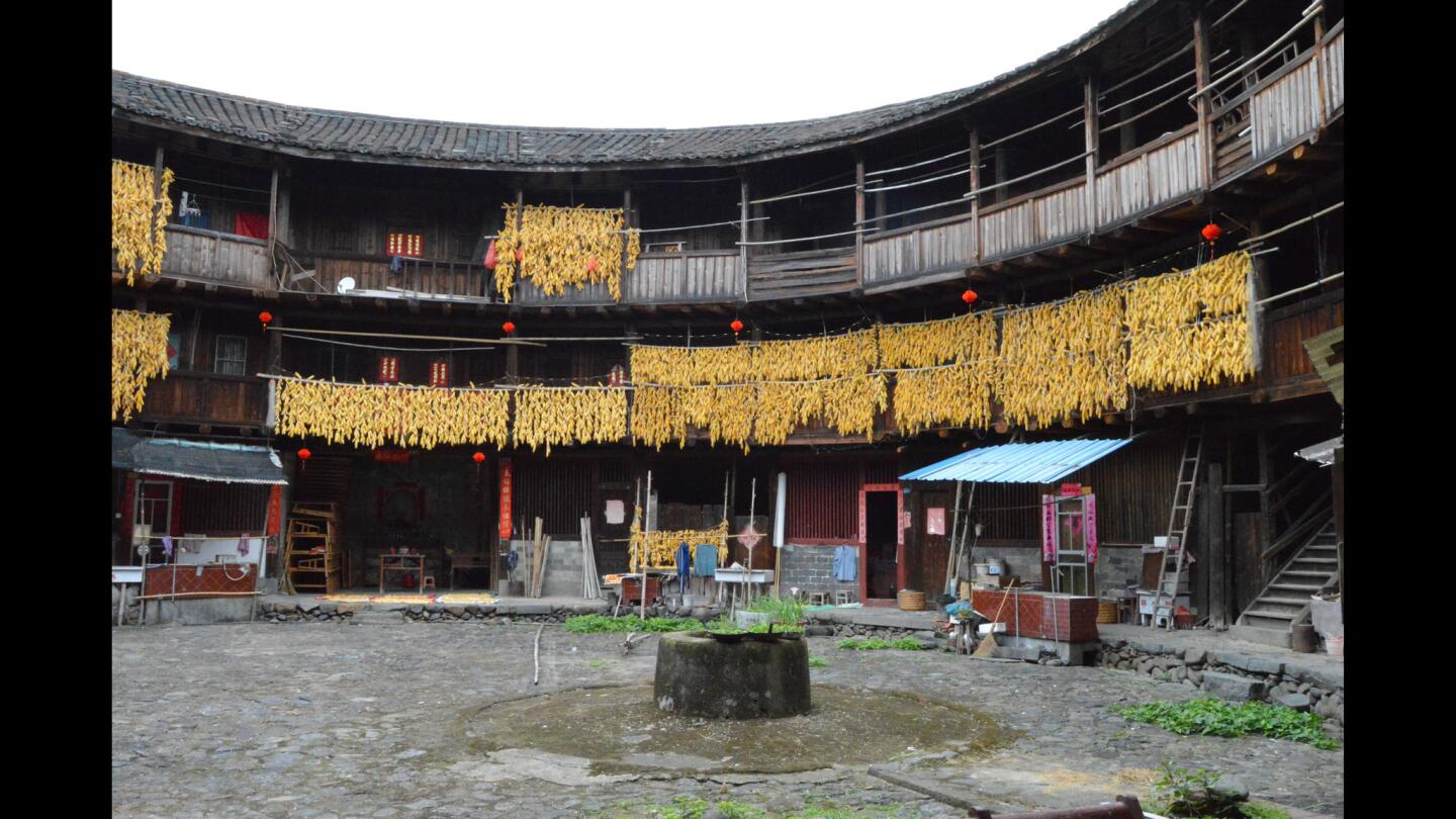 Corn ears dry from balconies inside a tulou in southeastern China. The structures are in an agricultural region that grows corn, tea, bamboo and citrus and other fruits.