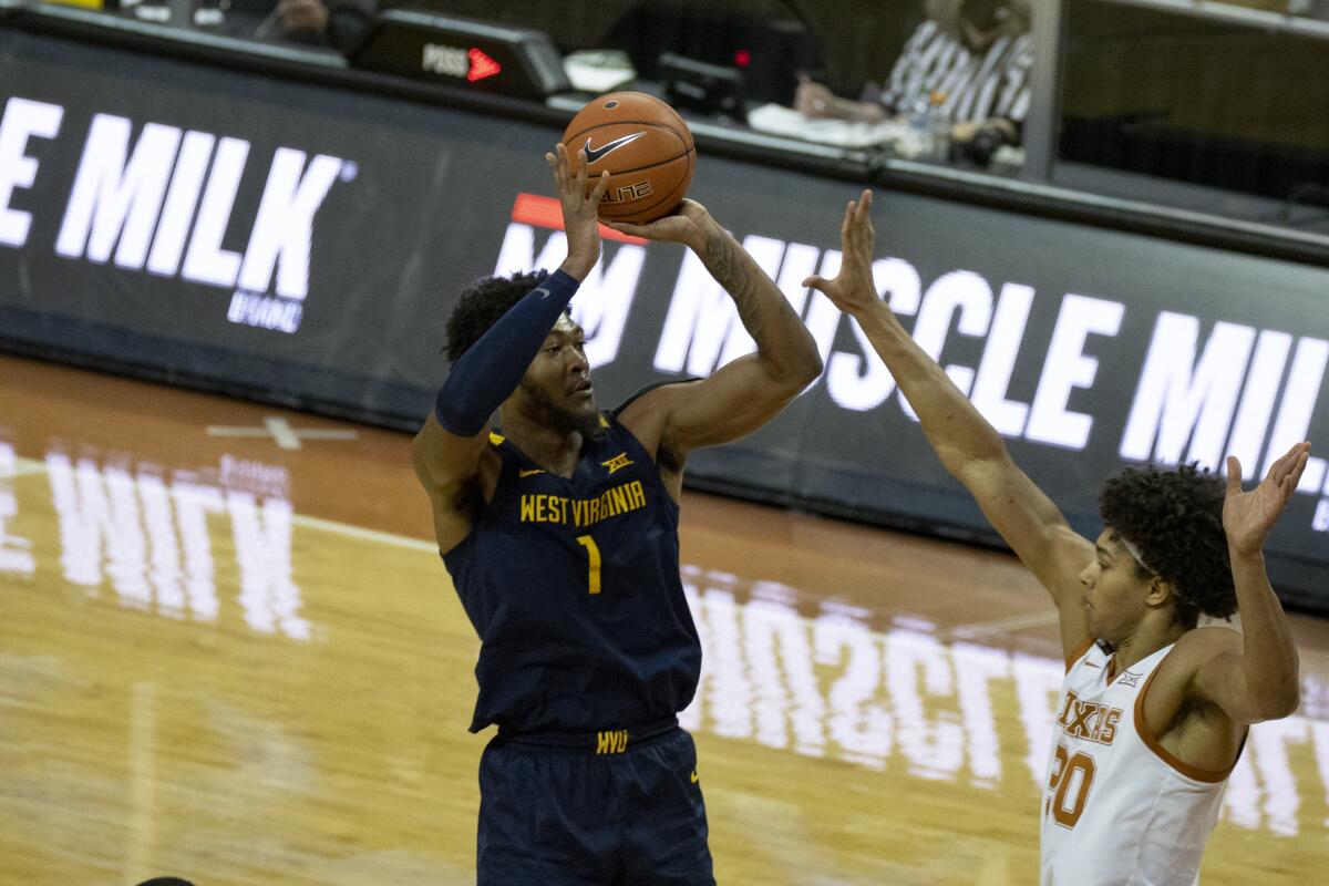 West Virginia's Derek Culver shoots over Texas' Jericho Sims during the second half Feb. 20, 2021.