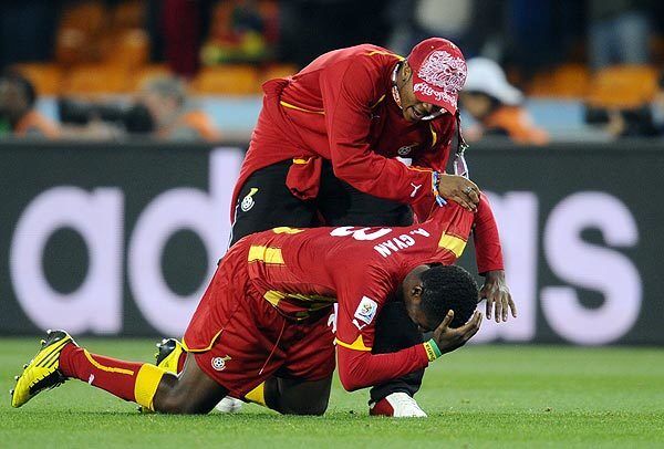 Ghana's striker Asamoah Gyan, at bottom, is comforted by a teammate after the team's loss to Uruguay in the 2010 World Cup quarterfinal.
