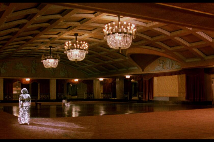 A ghostly figure of a woman walks through an empty Ambassador Hotel ballroom