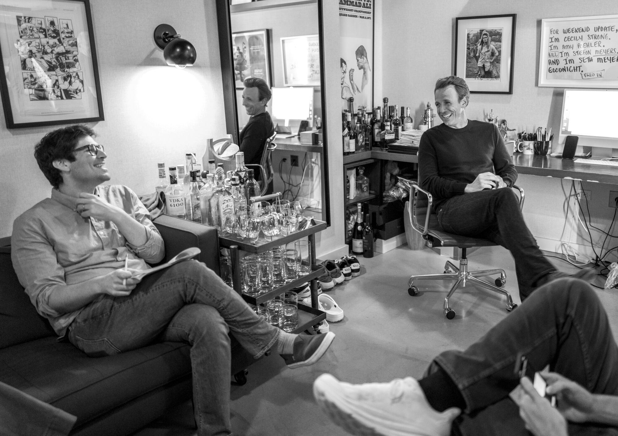 Sal Gentile, left, sits on a couch and looks at Seth Meyers, who is in a swivel chair.