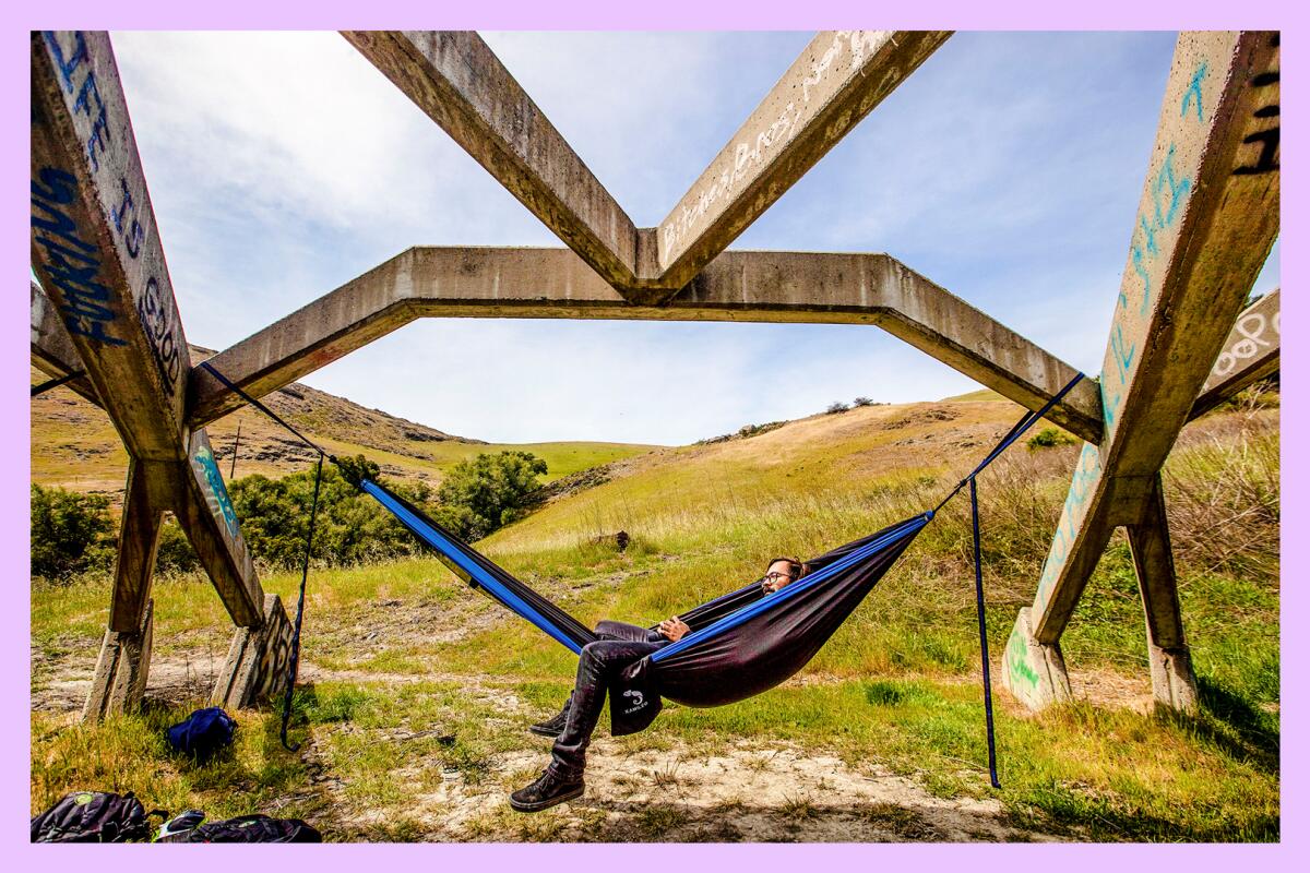 Cal Poly Student Hector Delgado relaxes in a hammock tethered to the "Poly Pavillion" at Poly Canyon