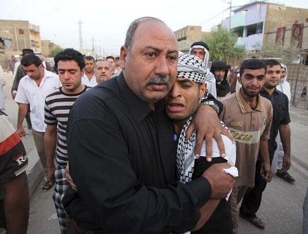 Family members and friends of a victim who was killed in the suicide bombing grieve at his funeral in Baghdad. On Sunday, at least 147 people were killed and 721 were wounded in two suicide bombings in the country's deadliest attack in more than two years.