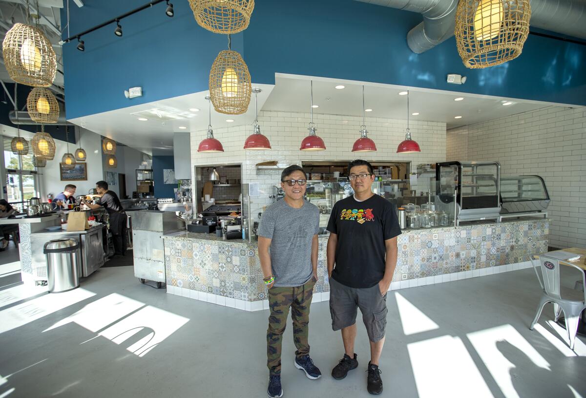Partners Ed Lee and John Park stand inside the Tustin location of Toast Kitchen & Bakery.