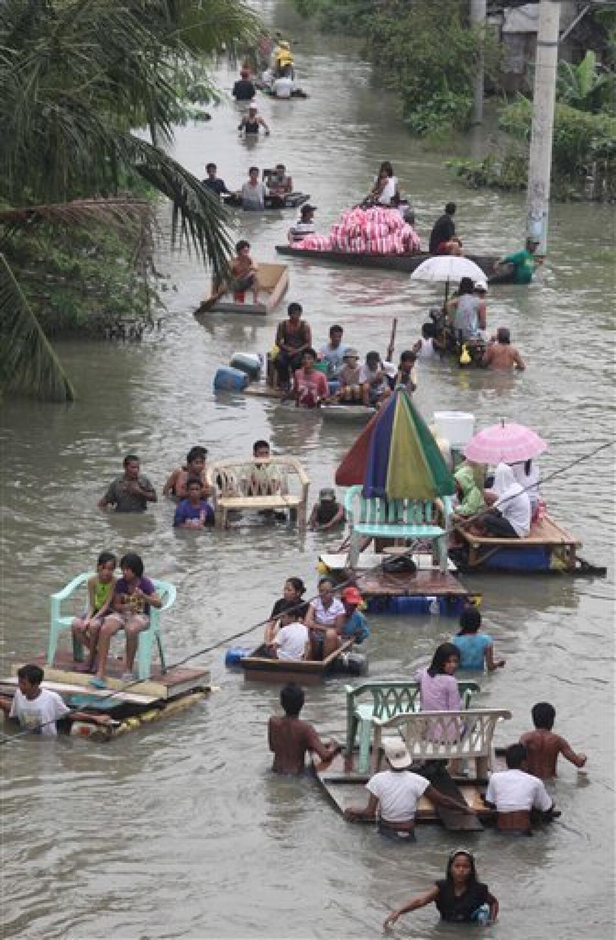 Residents go on with their normal life amidst floodwaters in Taytay township, Rizal province, east of Manila, Philippines Friday Oct. 2, 2009. Tropical storm Ketsana brought the worst flooding in metropolitan Manila and neighboring provinces in more than 40 years that left more than 250 people dead and dozens more missing. The Philippines is bracing for the super typhoon Parma which is expected to hit the northern part of the country Saturday. (AP Photo/Bullit Marquez)