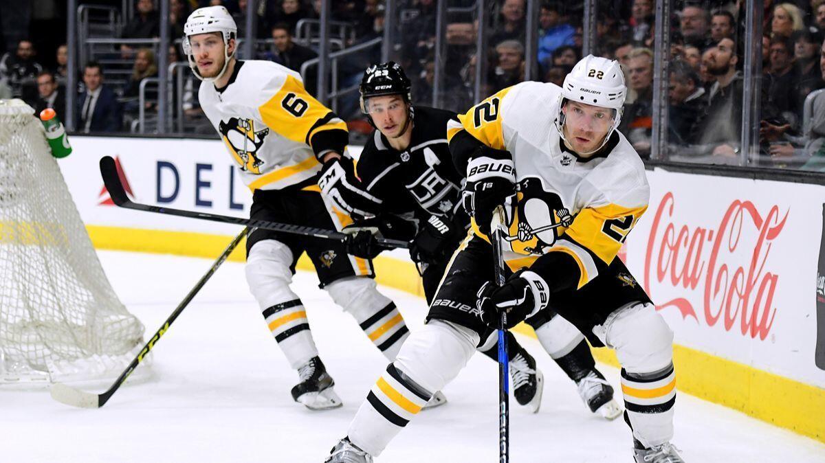 Pittsburgh Penguins' Matt Hunwick (22) clears the puck as he is chased by Kings' Dustin Brown and teammate Jamie Oleksiak (6) during the second period at Staples Center on Thursday.