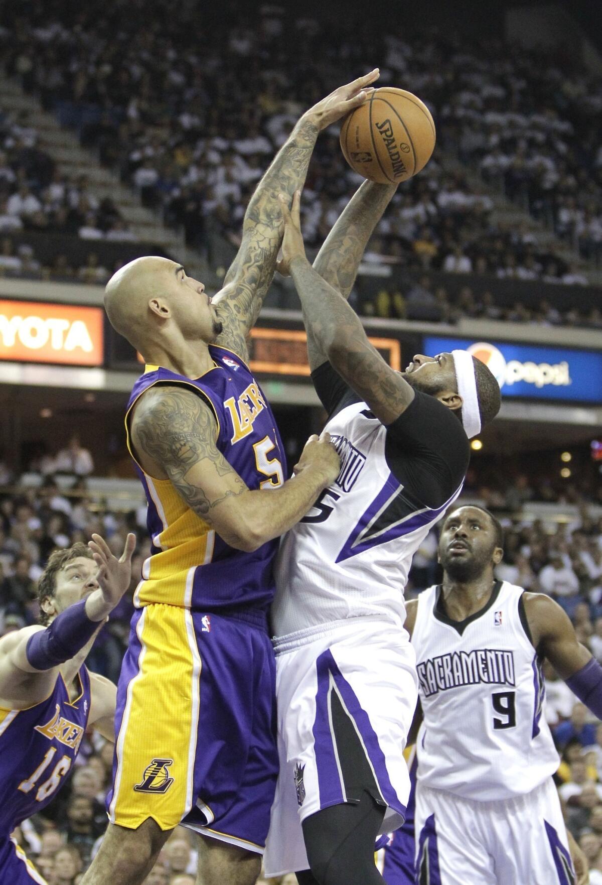Lakers center Robert Sacre blocks a shot by Kings center DeMarcus Cousins in December.