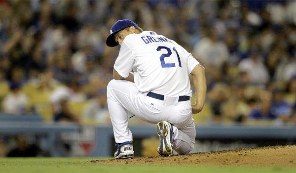 Zack Greinke kneels on the ground after giving up a two-run home run to Reds right fielder Jay Bruce (32) in the sixth inning of the Dodgers' 5-2 loss to Cincinnati on Thursday.