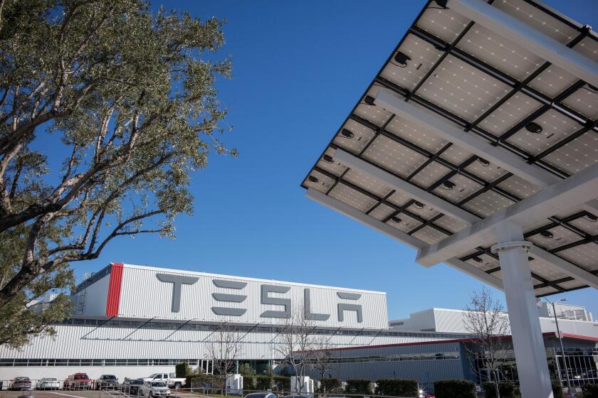 Electric car maker Tesla says it lost $154 million in the first quarter, compared with a loss of $49.8 million a year earlier. Revenue rose 51% to nearly $940 million. Above, Tesla’s car factory in Fremont, Calif.