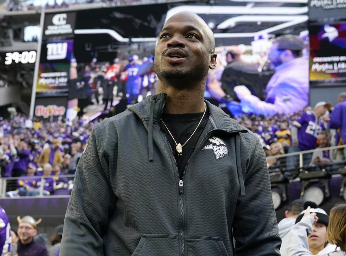 Former Minnesota Vikings running back Adrian Peterson stands on the field before an NFL wild-card playoff football game.