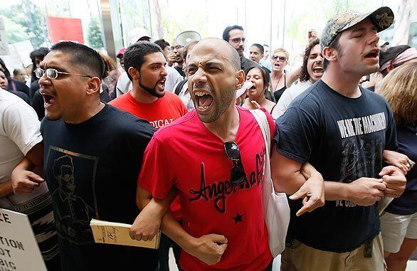 Robert Smith, center, leads the chants at Cal State Long Beach as demonstrators gather in the foyer of the Glenn S. Dumke Auditorium as CSU trustees meet to vote on faculty furloughs and student fee hikes in response to the state's newly approved budget.