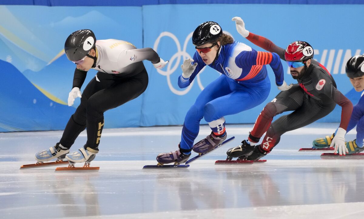 Gold medallist Shaoang Liu of Hungary, left, leads followed by silver medallist Konstantin Ivliev of the Russian Olympic Committee and bronze medallist Steven Dubois during the men's 500-meters at the short track speedskating competition at the 2022 Winter Olympics, Sunday, Feb. 13, 2022, in Beijing. (Paul Chiasson/The Canadian Press via AP