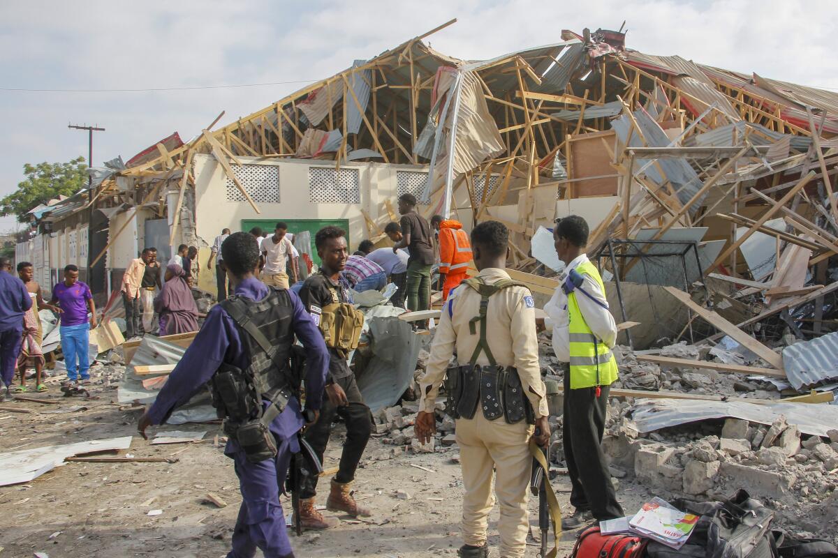 Rescue workers stand outside a collapsed building