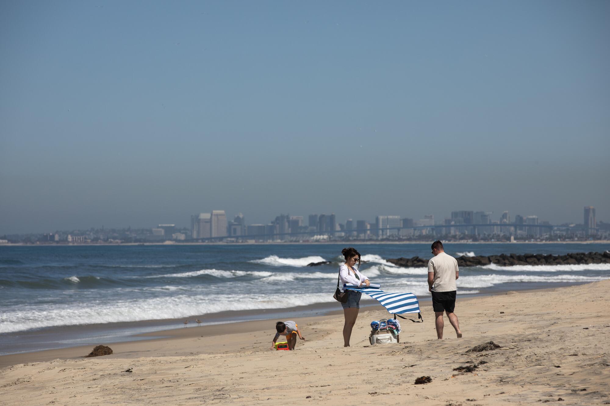 People enjoy a warm day on the sand April 9 in Imperial Beach.