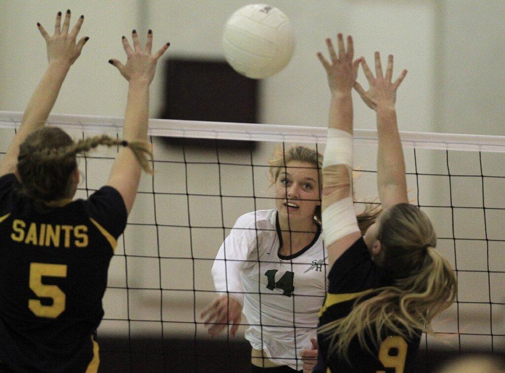 Sage Hill School's Halland McKenna (14) spikes the ball between Crean Lutheran's Kaila Wondergem (5) and Cassandra Roberts (9) during the first set in a CIF State Southern California Regional Division III semifinal match on Saturday.